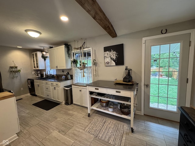 537 N 17th St, Noblesville, IN 46060 - kitchen featuring backsplash, dark countertops, beam ceiling, plenty of natural light, and white cabinets