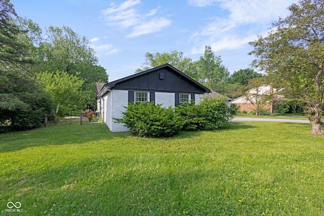 3141 Citadel Ct, Indianapolis, IN 46268 - view of home's exterior featuring board and batten siding, a lawn, and brick siding