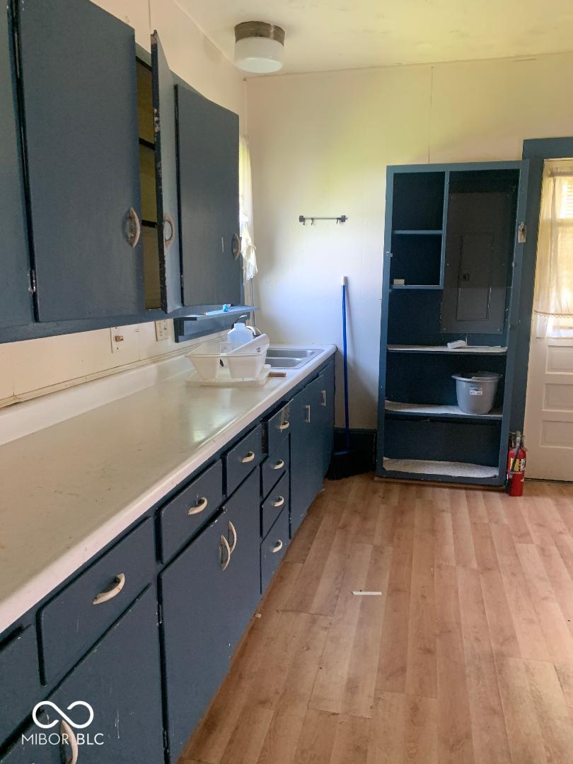 145 Hayden Pike, North Vernon, IN 47265 - kitchen featuring electric panel, light wood-style flooring, light countertops, and a sink