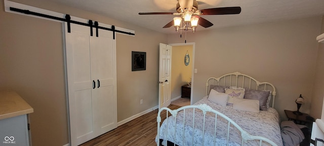 4232 Parliament Way, Avon, IN 46123 - bedroom with a barn door, wood finished floors, baseboards, and a ceiling fan