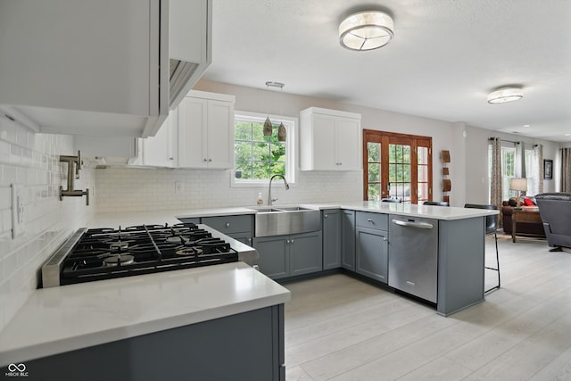 10410 Trillium Ct, Noblesville, IN 46060 - kitchen with stainless steel dishwasher, gray cabinetry, a sink, open floor plan, and decorative backsplash