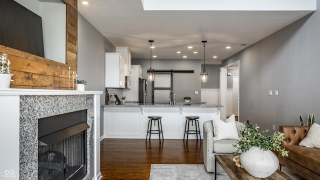 478 Firefly Ln, Carmel, IN 46032 - kitchen with freestanding refrigerator, white cabinets, dark wood-type flooring, light stone countertops, and a peninsula
