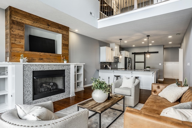 478 Firefly Ln, Carmel, IN 46032 - living room with wood finished floors, recessed lighting, a tiled fireplace, baseboards, and a high ceiling