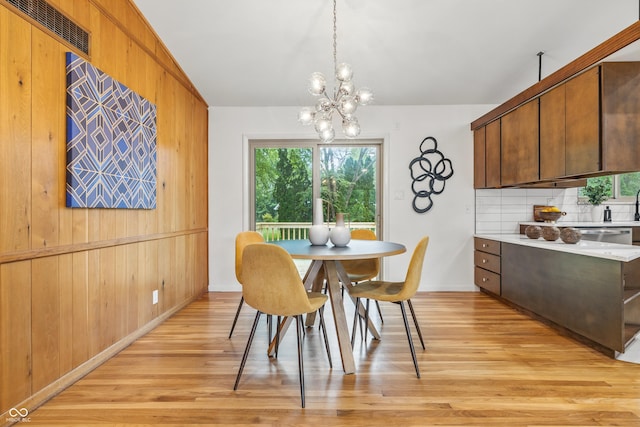 6704 Hoover Rd, Indianapolis, IN 46260 - dining area with light wood-style floors, wood walls, and a chandelier
