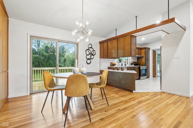 6704 Hoover Rd, Indianapolis, IN 46260 - dining room featuring lofted ceiling, light wood finished floors, a chandelier, and baseboards