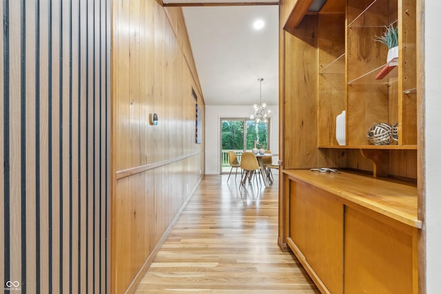 6704 Hoover Rd, Indianapolis, IN 46260 - hall featuring light wood finished floors, a chandelier, and wood walls