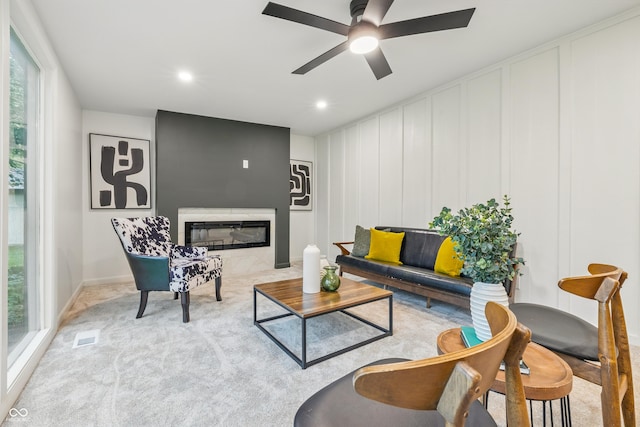 6704 Hoover Rd, Indianapolis, IN 46260 - carpeted living area featuring a decorative wall, ceiling fan, a glass covered fireplace, and recessed lighting