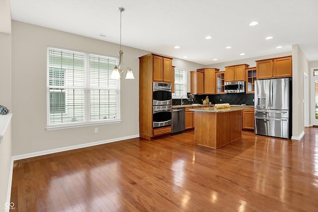 13528 Cuppertino Ln, Carmel, IN 46074 - kitchen featuring stainless steel appliances, brown cabinetry, glass insert cabinets, dark wood-style flooring, and decorative backsplash