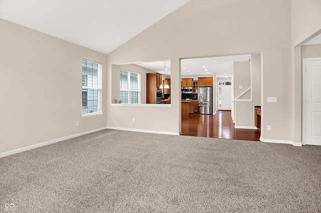13528 Cuppertino Ln, Carmel, IN 46074 - unfurnished living room with dark carpet and high vaulted ceiling