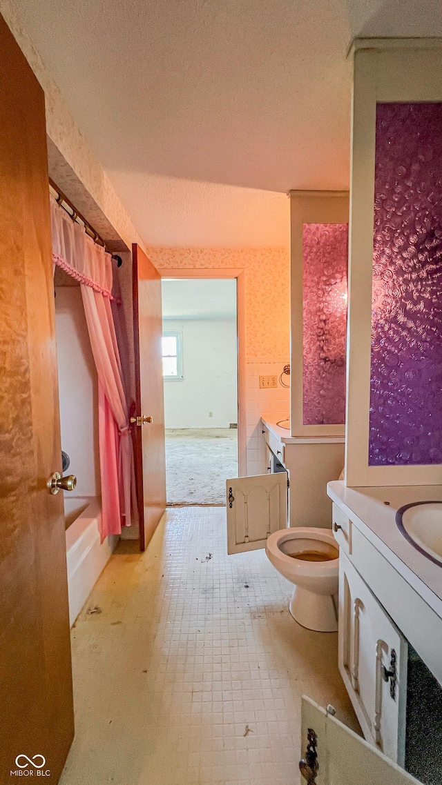 3215 E 10th St, Anderson, IN 46012 - full bathroom featuring toilet, vanity, a textured ceiling, and shower / bathtub combination with curtain
