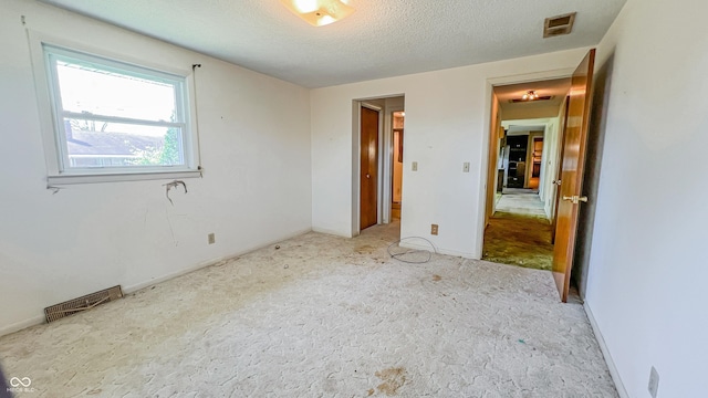 3215 E 10th St, Anderson, IN 46012 - unfurnished bedroom featuring carpet and a textured ceiling
