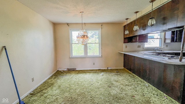 3215 E 10th St, Anderson, IN 46012 - kitchen with plenty of natural light, carpet flooring, a chandelier, baseboards, and a textured ceiling