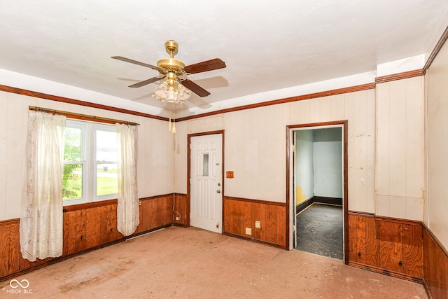 2009 S L St, Elwood, IN 46036 - empty room featuring a ceiling fan, wood walls, and a wainscoted wall