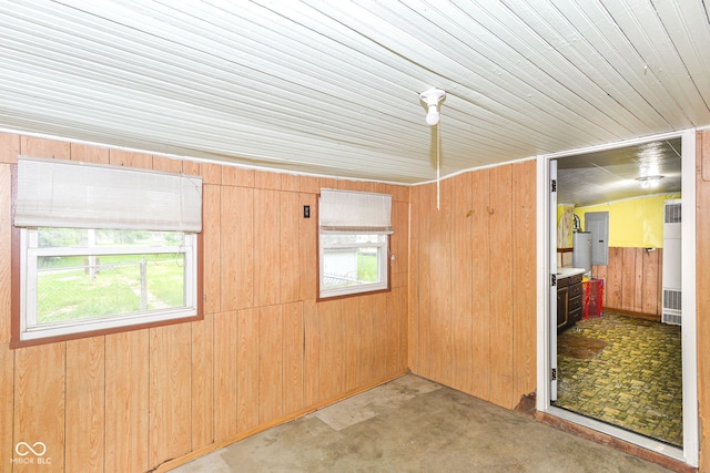 2009 S L St, Elwood, IN 46036 - unfurnished room featuring plenty of natural light, wood walls, a heating unit, and concrete floors