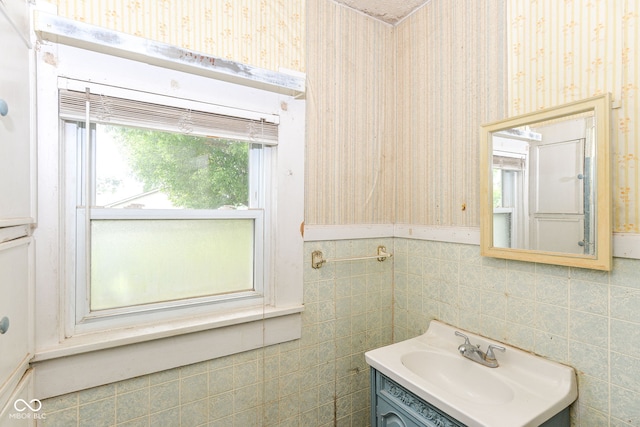 2009 S L St, Elwood, IN 46036 - bathroom featuring wallpapered walls, vanity, tile walls, and a wainscoted wall