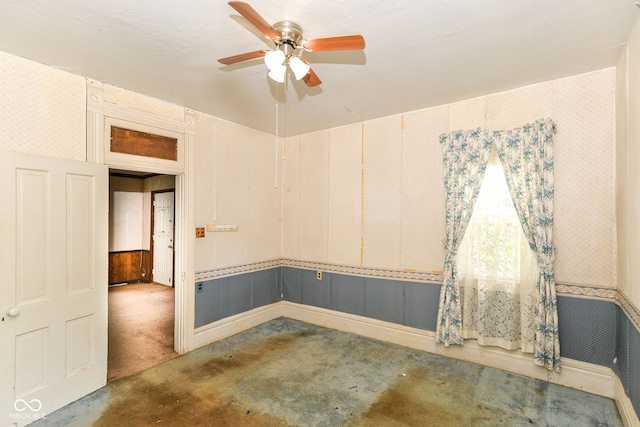 2009 S L St, Elwood, IN 46036 - spare room with ceiling fan, unfinished concrete flooring, wallpapered walls, and a wainscoted wall