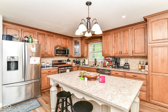 5651 Pine Knoll Blvd, Noblesville, IN 46062 - kitchen with appliances with stainless steel finishes, a sink, light wood-style flooring, a chandelier, and recessed lighting