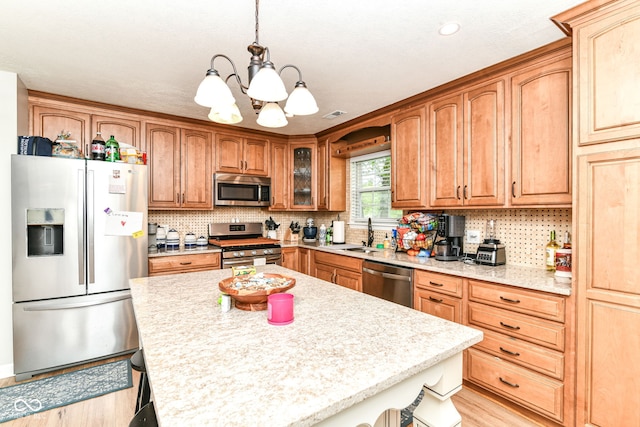 5651 Pine Knoll Blvd, Noblesville, IN 46062 - kitchen featuring appliances with stainless steel finishes, a breakfast bar area, a chandelier, a sink, and light wood-type flooring
