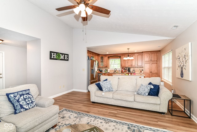 5651 Pine Knoll Blvd, Noblesville, IN 46062 - living area with vaulted ceiling, light wood finished floors, baseboards, a ceiling fan, and a chandelier