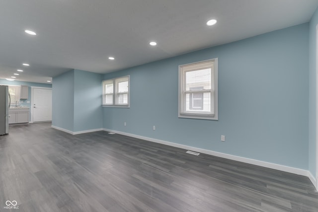 2945 N Denny St, Indianapolis, IN 46218 - unfurnished living room with a sink, baseboards, recessed lighting, and dark wood-type flooring