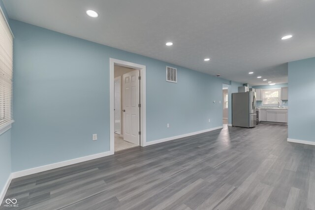 2945 N Denny St, Indianapolis, IN 46218 - unfurnished living room with dark wood-style floors, recessed lighting, baseboards, and a sink
