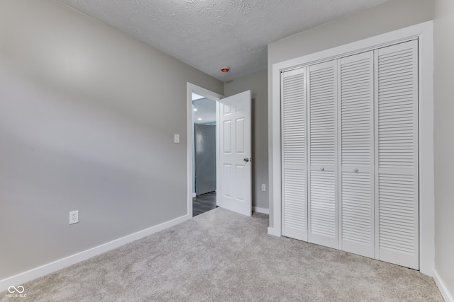 2945 N Denny St, Indianapolis, IN 46218 - unfurnished bedroom featuring carpet flooring, a closet, a textured ceiling, and baseboards