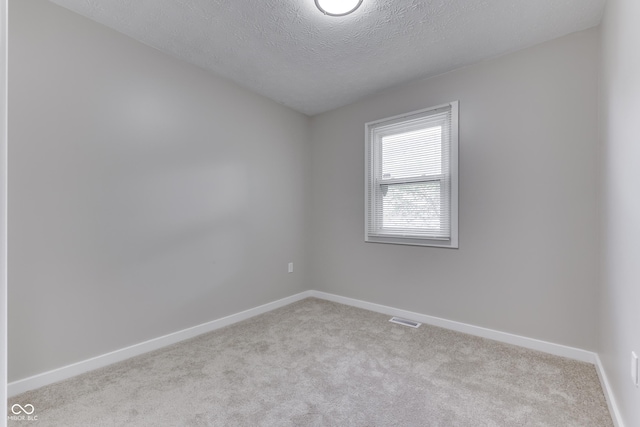 2945 N Denny St, Indianapolis, IN 46218 - carpeted spare room featuring baseboards and a textured ceiling