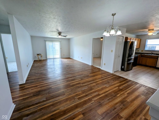 581 Grassy Bend Dr, Greenwood, IN 46143 - unfurnished living room with ceiling fan, wood finished floors, a chandelier, and a textured ceiling