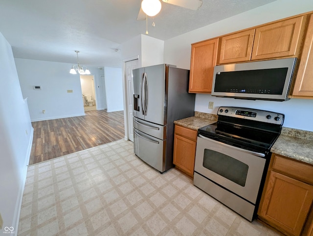 581 Grassy Bend Dr, Greenwood, IN 46143 - kitchen with appliances with stainless steel finishes, light flooring, a chandelier, a ceiling fan, and baseboards