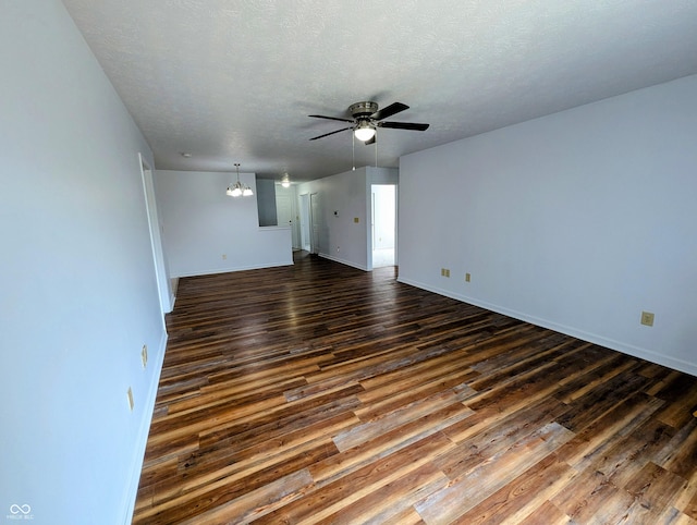581 Grassy Bend Dr, Greenwood, IN 46143 - spare room with ceiling fan, dark wood-style flooring, a chandelier, baseboards, and a textured ceiling