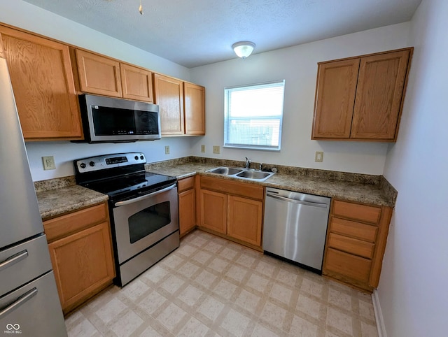 581 Grassy Bend Dr, Greenwood, IN 46143 - kitchen featuring appliances with stainless steel finishes, a sink, light flooring, and dark countertops