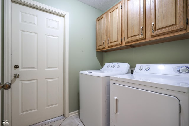 4462 Carya Sq, Columbus, IN 47201 - washroom featuring washer and clothes dryer, cabinet space, and light tile patterned floors