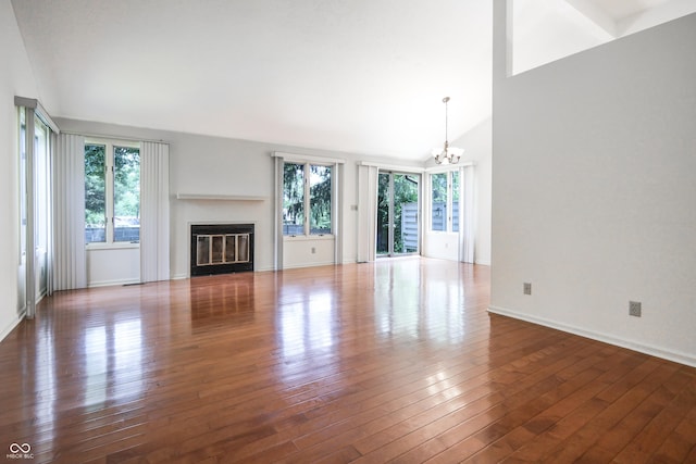 4462 Carya Sq, Columbus, IN 47201 - unfurnished living room with a chandelier, lofted ceiling, wood-type flooring, a glass covered fireplace, and baseboards