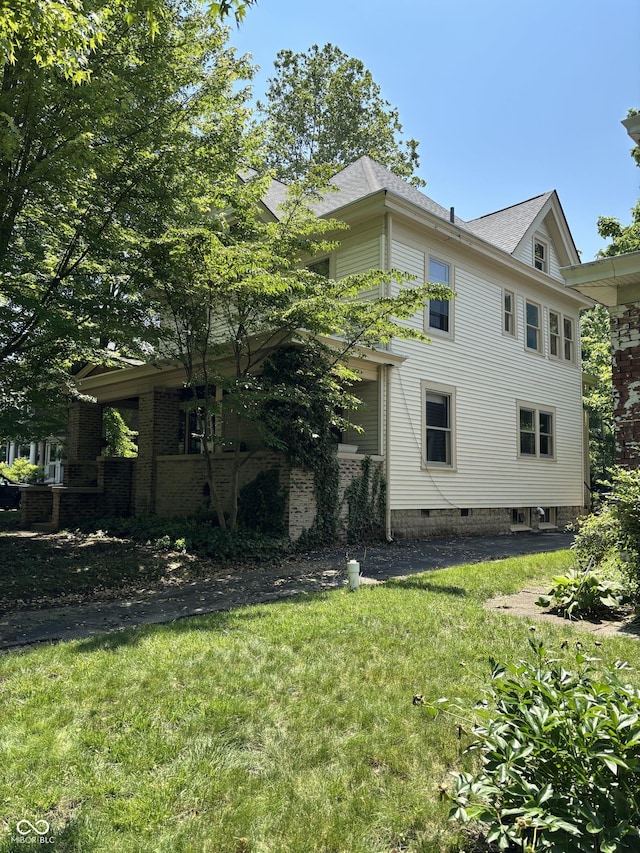 48 N Audubon Rd, Indianapolis, IN 46219 - view of side of home featuring a lawn and roof with shingles