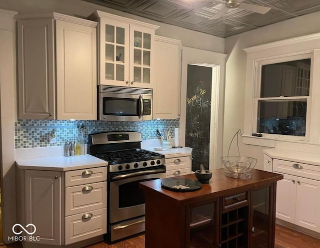 48 N Audubon Rd, Indianapolis, IN 46219 - kitchen featuring stainless steel appliances, an ornate ceiling, ceiling fan, backsplash, and glass insert cabinets