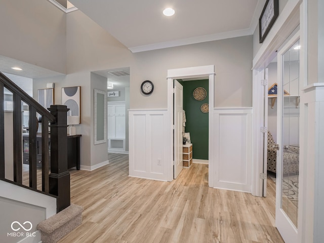 5684 Autumn Trl, Brownsburg, IN 46112 - entrance foyer featuring stairs, a decorative wall, light wood finished floors, wainscoting, and crown molding