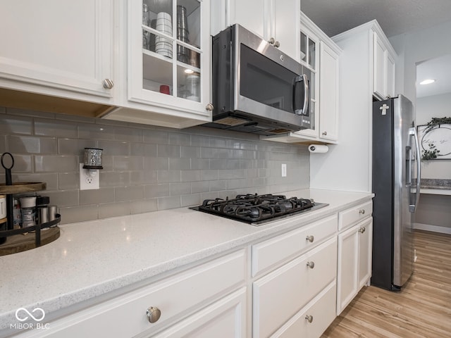 5684 Autumn Trl, Brownsburg, IN 46112 - kitchen featuring stainless steel appliances, white cabinets, glass insert cabinets, and backsplash