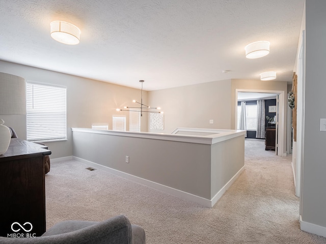 5684 Autumn Trl, Brownsburg, IN 46112 - corridor featuring light carpet, a chandelier, baseboards, and a textured ceiling
