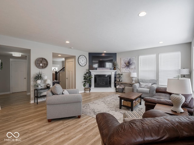 5684 Autumn Trl, Brownsburg, IN 46112 - living room with light wood-style flooring, baseboards, a glass covered fireplace, recessed lighting, and stairway
