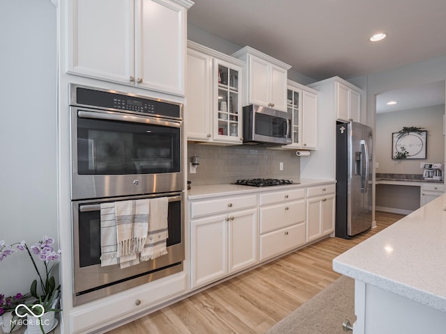 5684 Autumn Trl, Brownsburg, IN 46112 - kitchen featuring stainless steel appliances, white cabinetry, recessed lighting, decorative backsplash, and glass insert cabinets