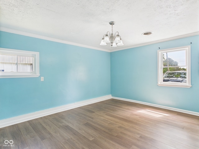 4020 N Mitthoefer Rd, Indianapolis, IN 46235 - empty room featuring a chandelier, a textured ceiling, baseboards, wood finished floors, and ornamental molding