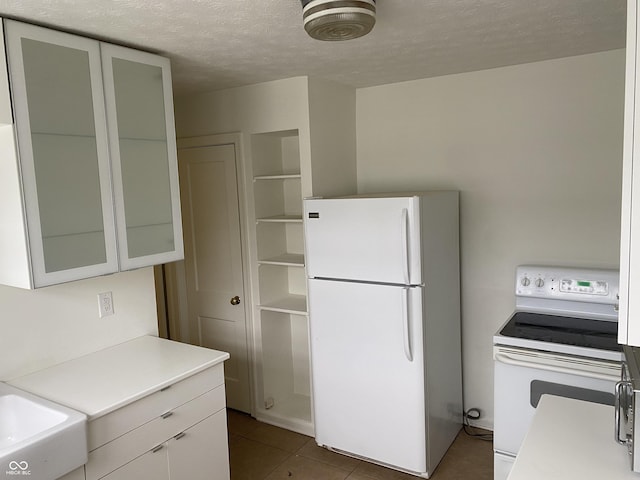 1444 N Denny St, Indianapolis, IN 46201 - kitchen featuring white appliances, light countertops, a textured ceiling, tile patterned flooring, and a sink