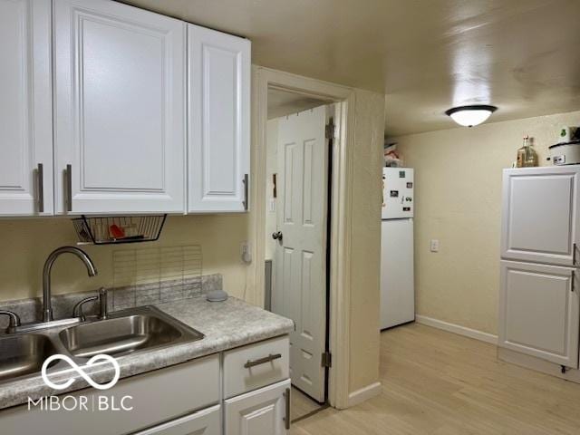 1118 S 2nd St, Lafayette, IN 47905 - kitchen with freestanding refrigerator, a sink, white cabinetry, and baseboards