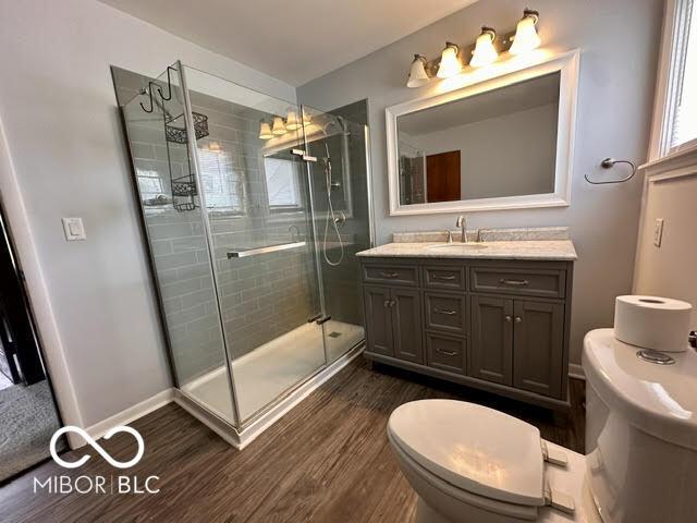 323 W 8th St, Rushville, IN 46173 - full bathroom with toilet, wood finished floors, vanity, and a stall shower