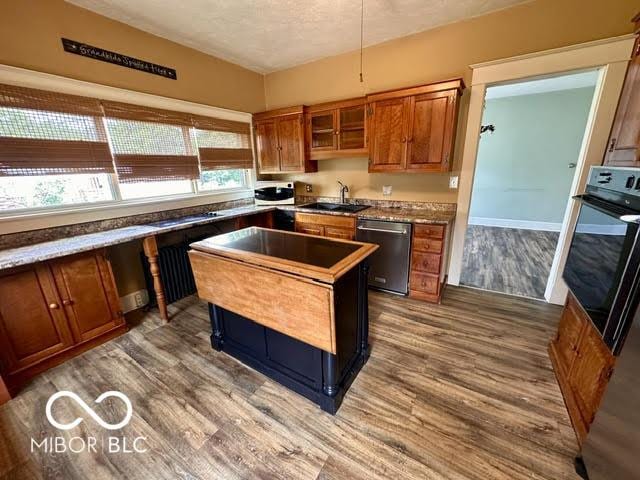 323 W 8th St, Rushville, IN 46173 - kitchen featuring dishwasher, a sink, wood finished floors, oven, and a textured ceiling