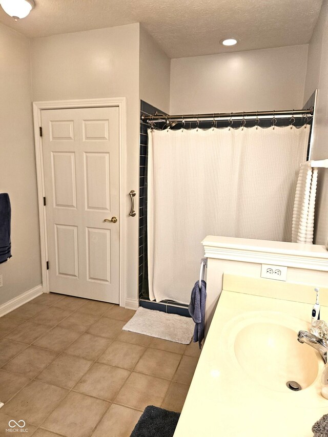 6956 Park Square Dr Unit D, Avon, IN 46123 - bathroom featuring curtained shower, tile patterned floors, vanity, a textured ceiling, and baseboards