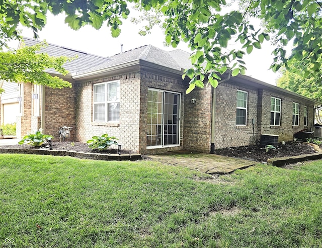 6956 Park Square Dr Unit D, Avon, IN 46123 - view of side of home with a lawn, central AC, brick siding, and a shingled roof