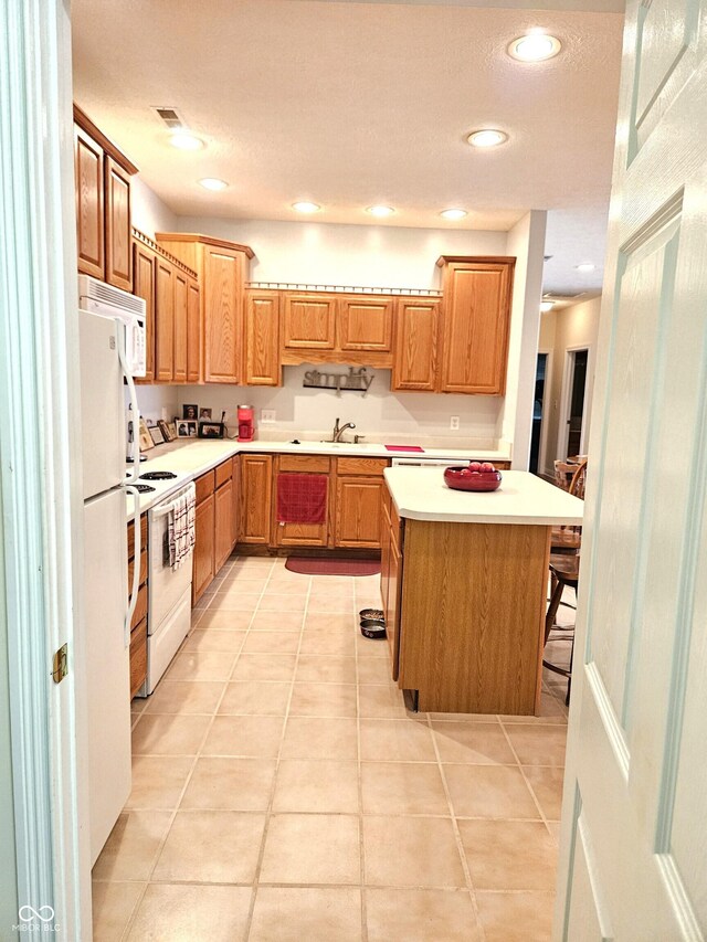 6956 Park Square Dr Unit D, Avon, IN 46123 - kitchen with white appliances, light countertops, a center island, light tile patterned floors, and recessed lighting
