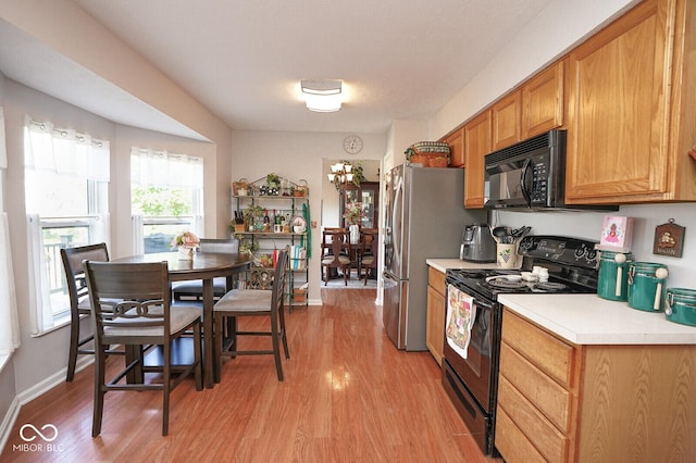 4342 Sequoia Ct, Greenwood, IN 46143 - kitchen featuring black appliances, light wood-type flooring, light countertops, and a chandelier