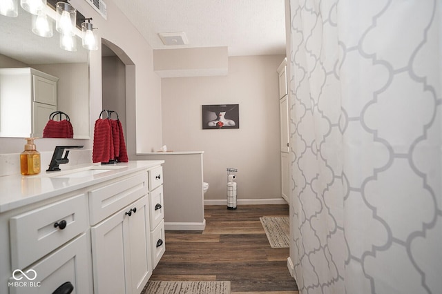 4342 Sequoia Ct, Greenwood, IN 46143 - bathroom featuring vanity, wood finished floors, toilet, baseboards, and a textured ceiling